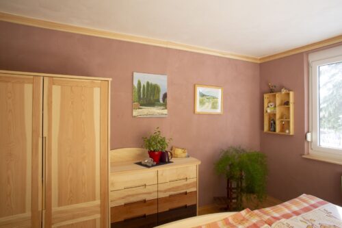 Saniertes Schlafzimmer mit Naturmaterialien und hochwertigen Vollholzmöbeln