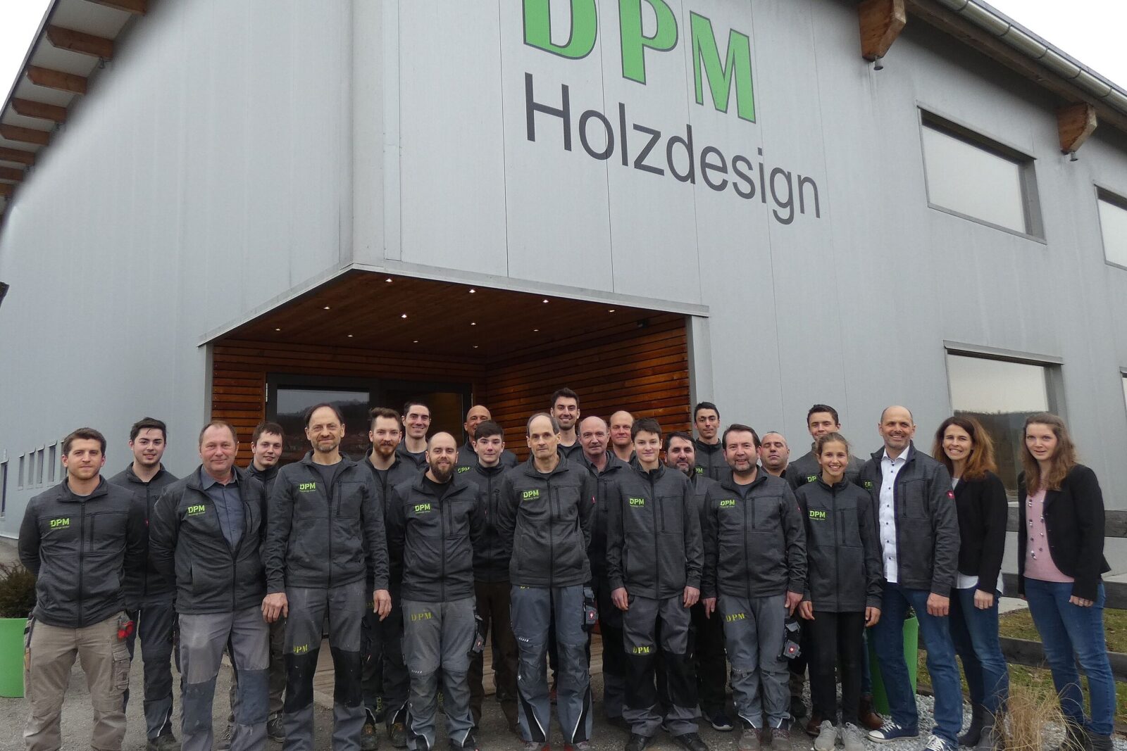 Das Team von DPM Holzdesign posiert vor dem Firmengebäude